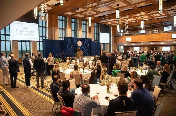 Dahnke ballroom full of people speaking as Shannon Cullinan gives remarks.