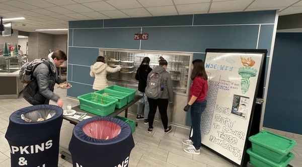 Students in the Norht Dining Hall are scraping their scraps of food off into green bins for the Grind2Energy system.