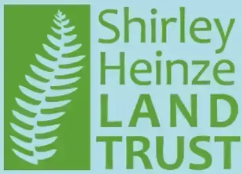 Shirley Heinze Land Trust logo with a light green fern frond on a dark green rectangle.