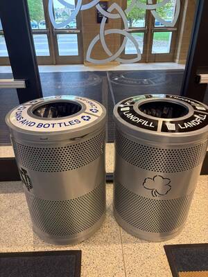 Two silver bins: one for Cans and Bottles recycling, one for Landfill with a Notre Dame shamrock logo.